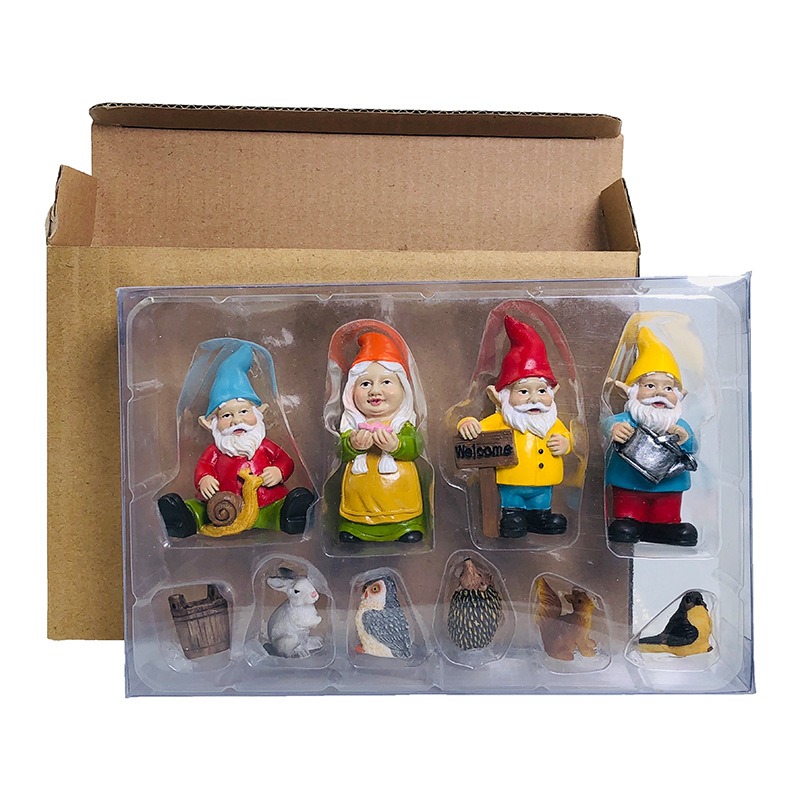 Gnome figurines resting in a clear tray inside an open kraft gift box