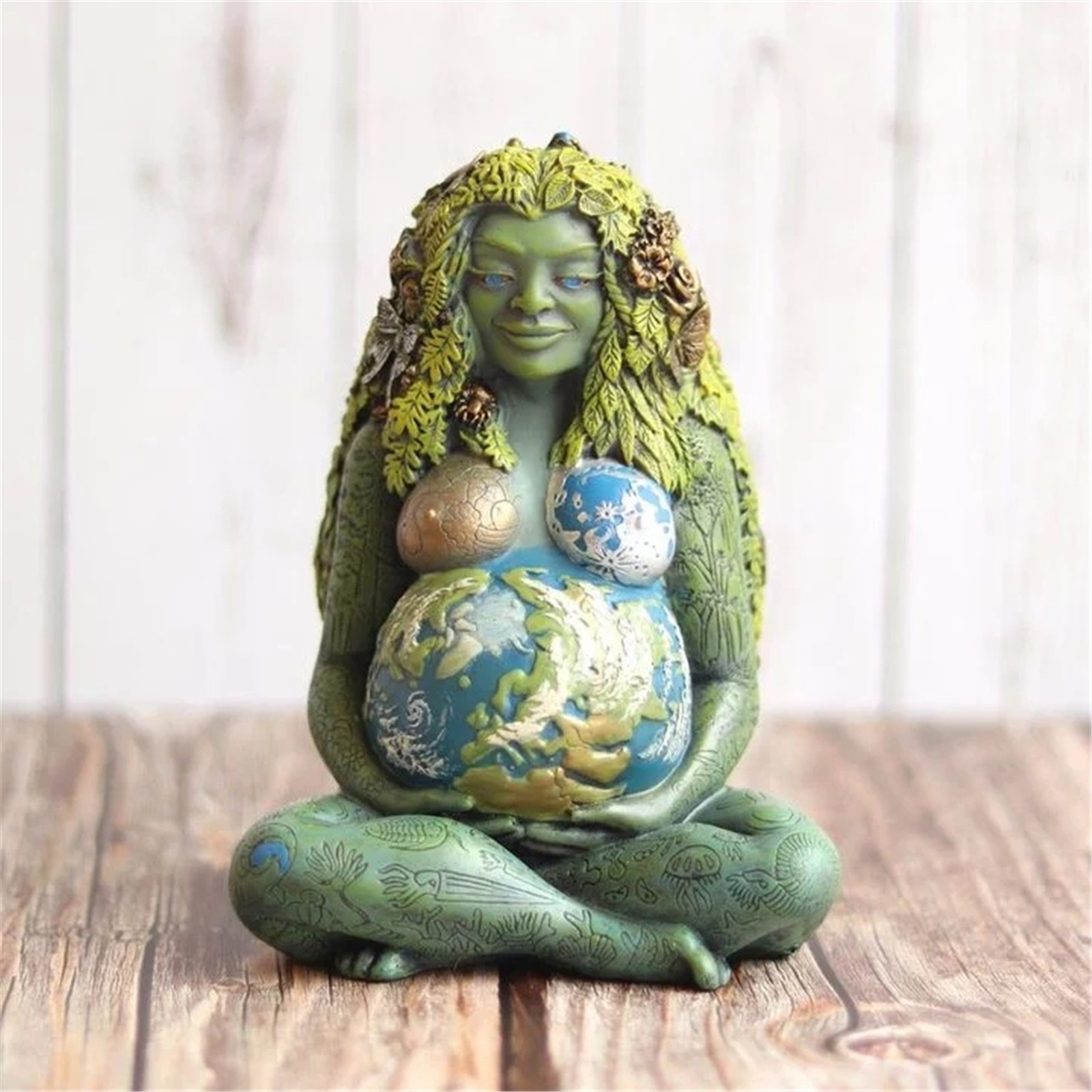 Gaia statue on a rustic wooden table before a weathered wood backdrop