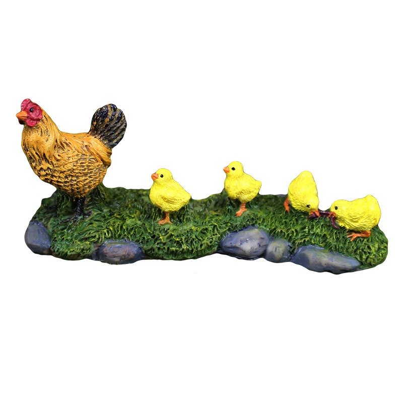 Hen and chicks figurine on moss base with grey stones, full view