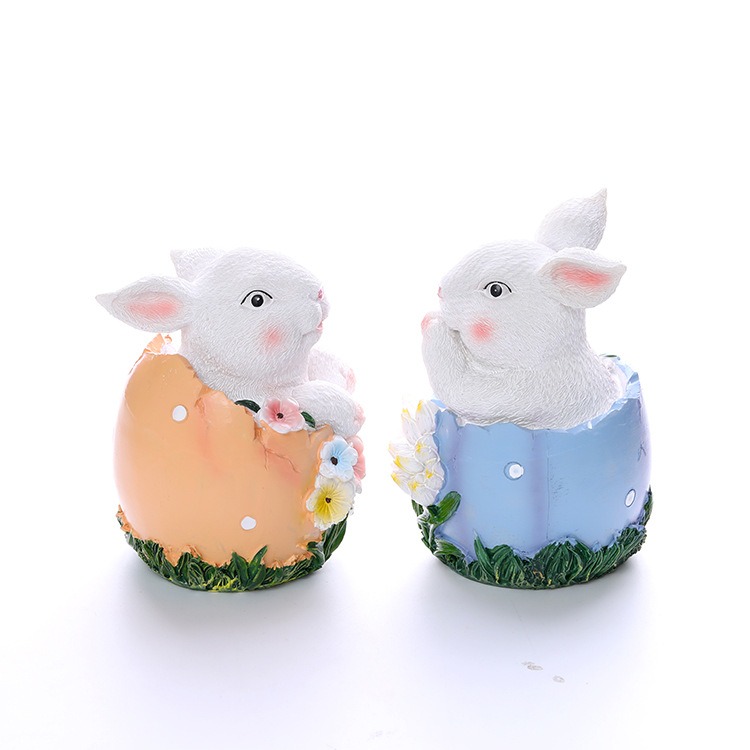 Peach and blue rabbit egg statues displayed side by side