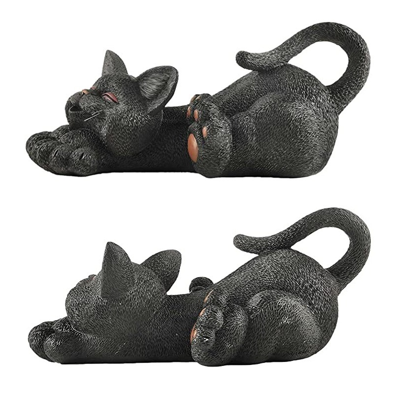 Resin garden cat figurine photographed in a relaxed outdoor setting