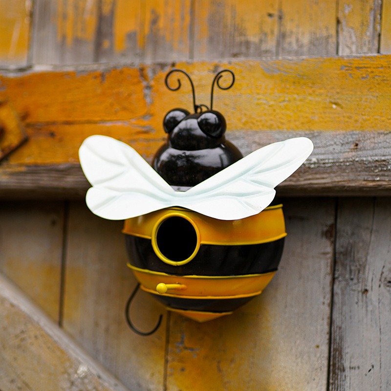 Bumblebee bird house mounted on a weathered wooden wall with hook