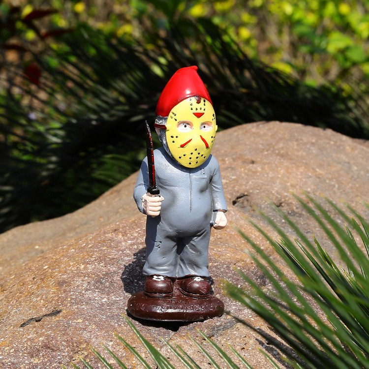 Garden figurine standing outdoors among green plants in bright sunlight