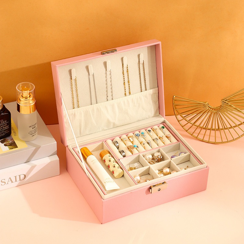 Jewelry scattered across a dressing table beside skincare bottles