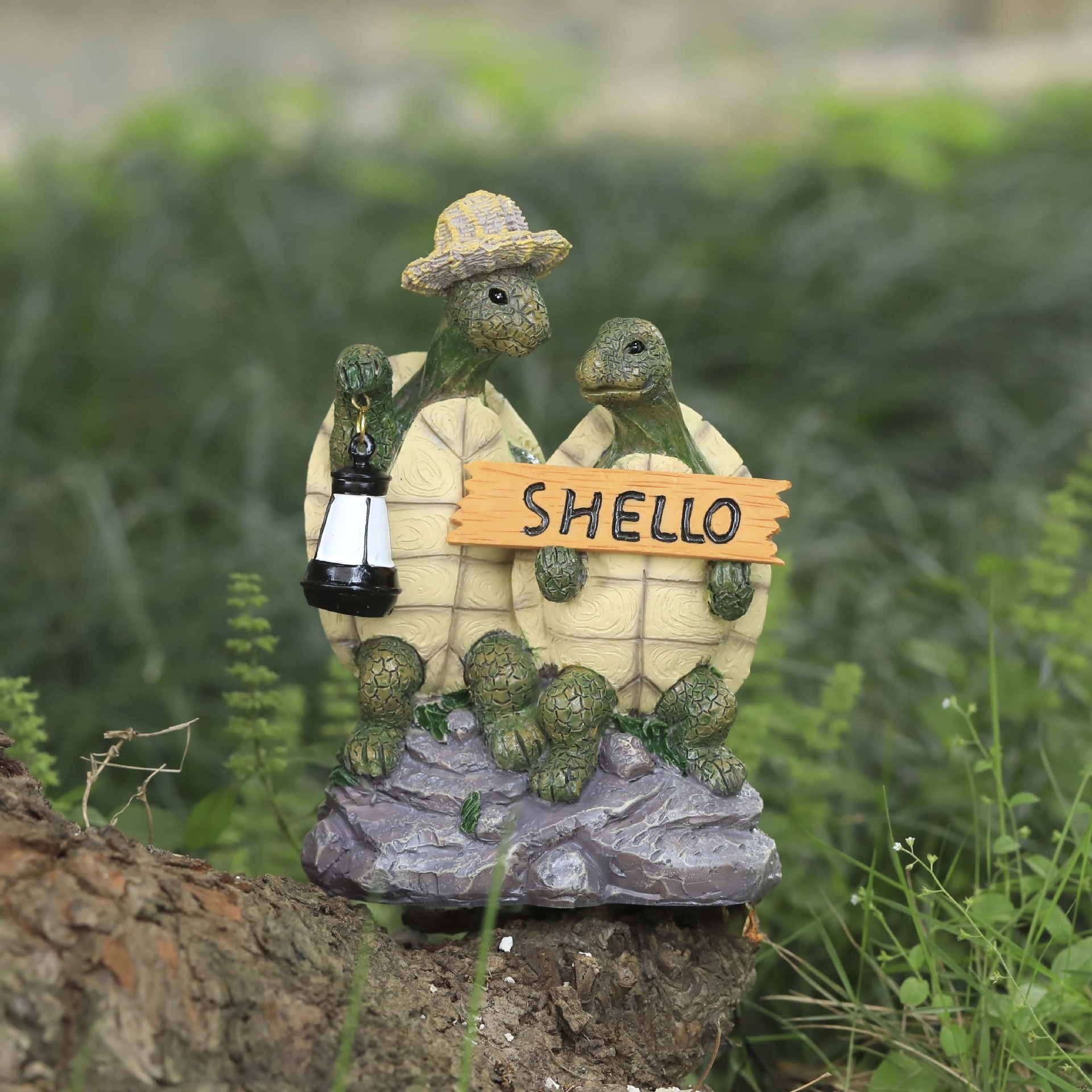 Turtle couple figurine on a log with wildflowers and grass behind