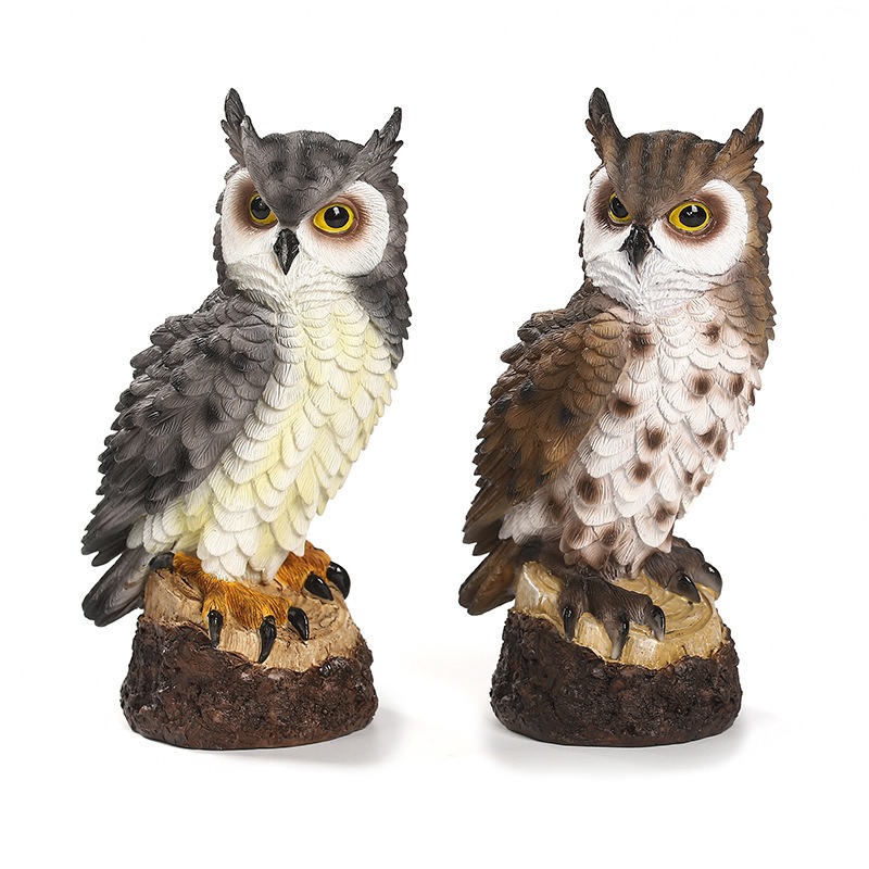 Grey and brown resin owls on tree-stump bases in a garden setting