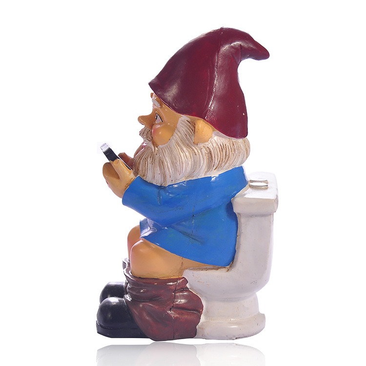 Side profile of resin gnome seated on a white toilet holding a phone