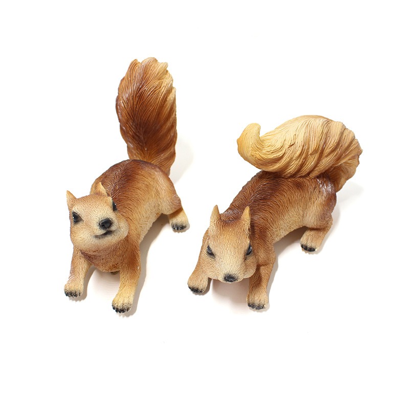Top-down view of two squirrel figurines showing tail curl and head posture