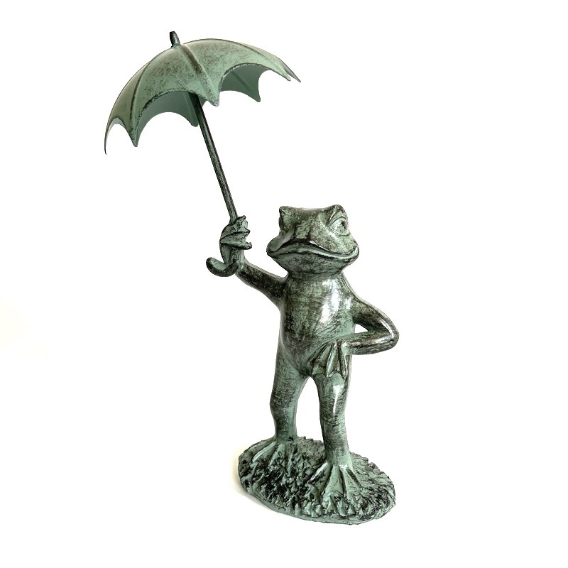 Front view of frog ornament standing on grassy base with umbrella raised