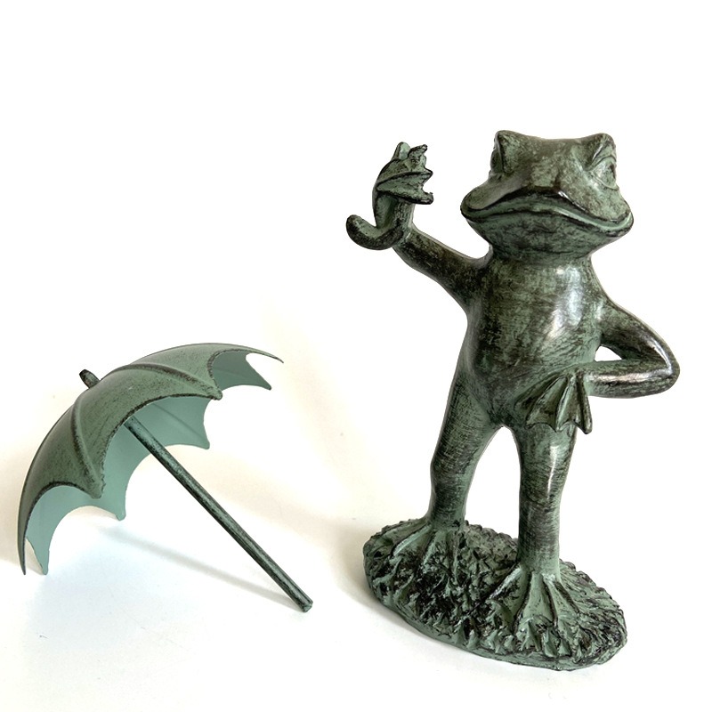 Close view of the frog figure with textured grass base and sculpted face