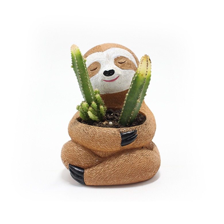Sloth planter filled with soil and two cacti, head peeking above