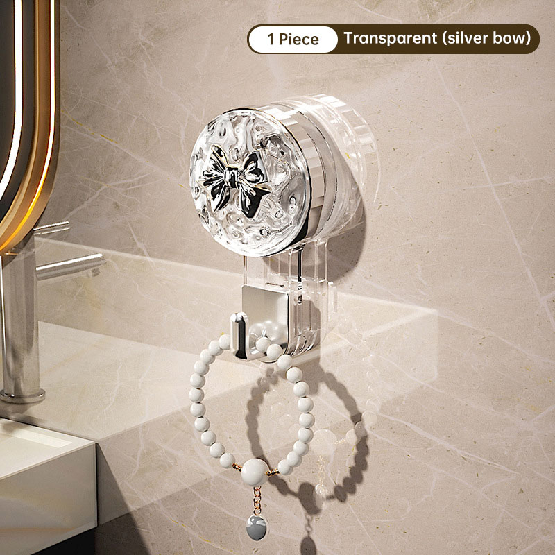 Single clear suction hook on a marble bathroom wall holding a pearl bracelet