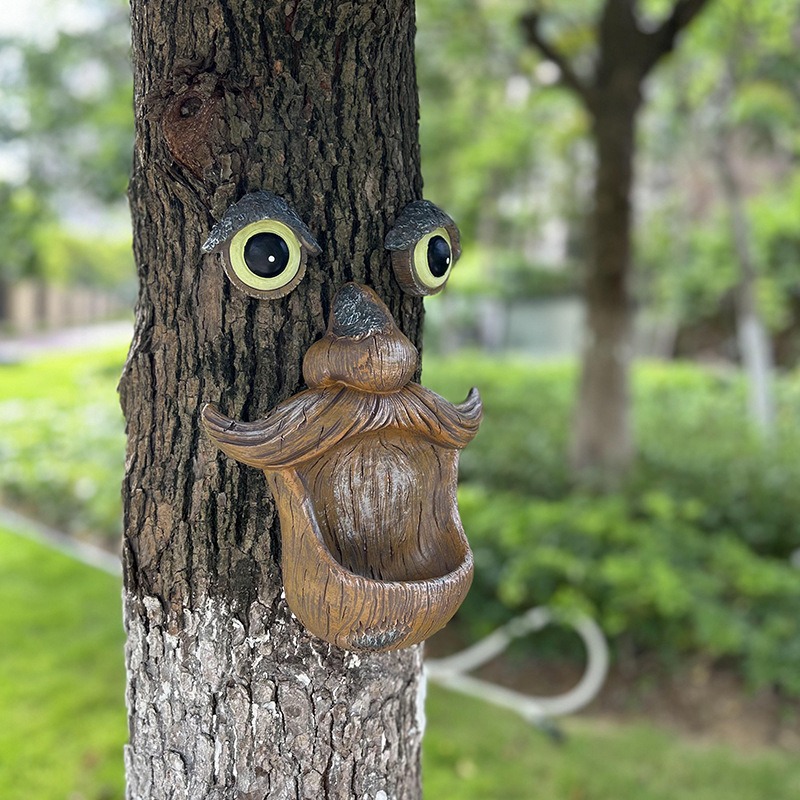 Side view of the tree face with moustache and open mouth on greenery