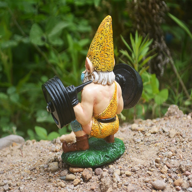Gnome on gravel in a garden with green foliage behind