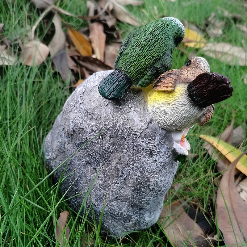 Welcome stone sitting bare on a lawn beside dry leaves