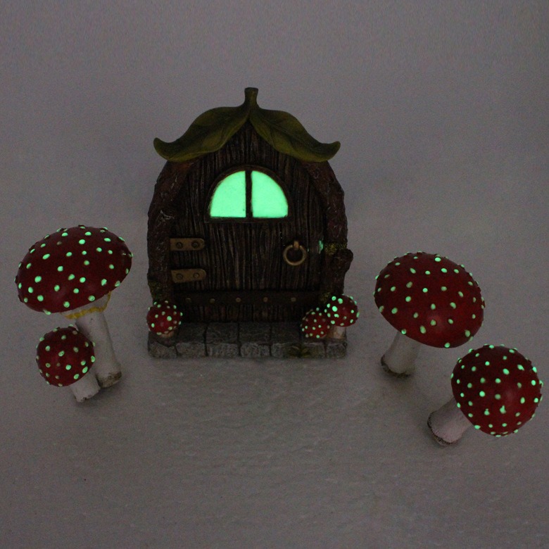 Fairy door and toadstools placed at the base of a garden tree