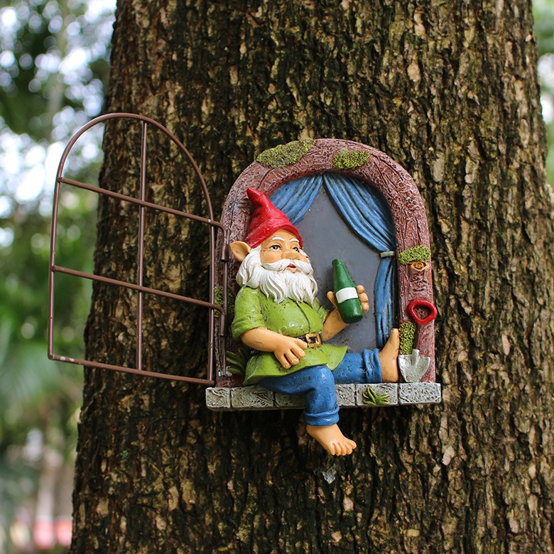 Gnome window decoration mounted on a large tree trunk in a garden