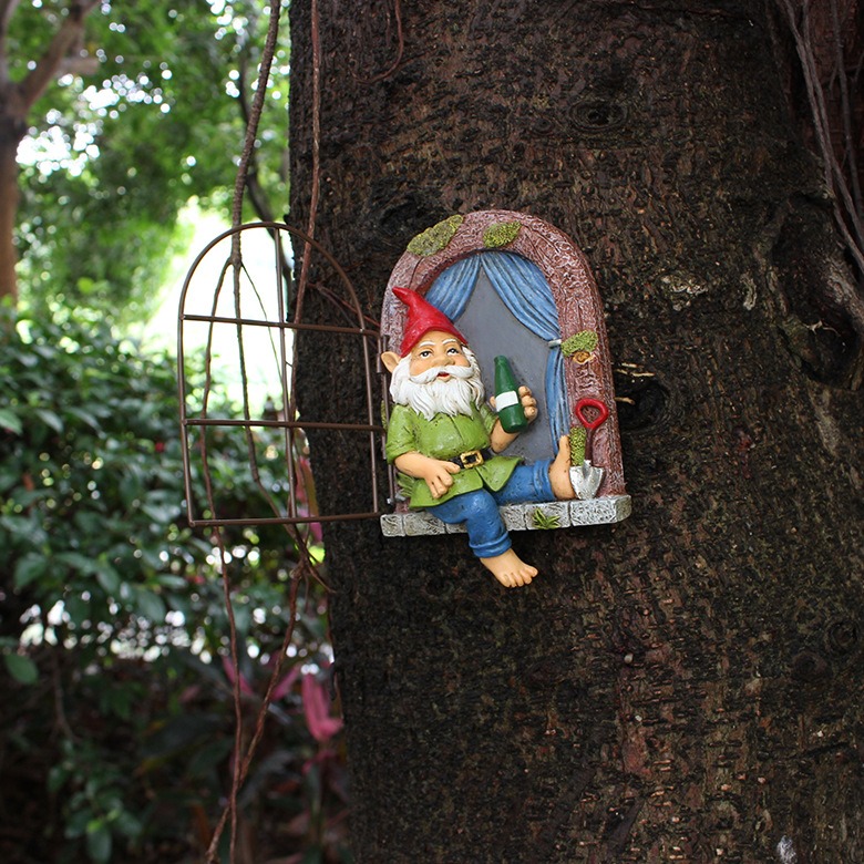 Gnome tree window decoration with open iron frame on tree in a garden setting