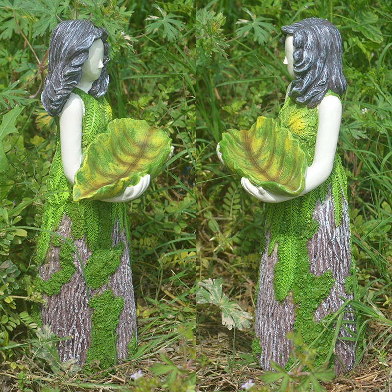 Side view of resin garden figure with bark skirt and leaf tray