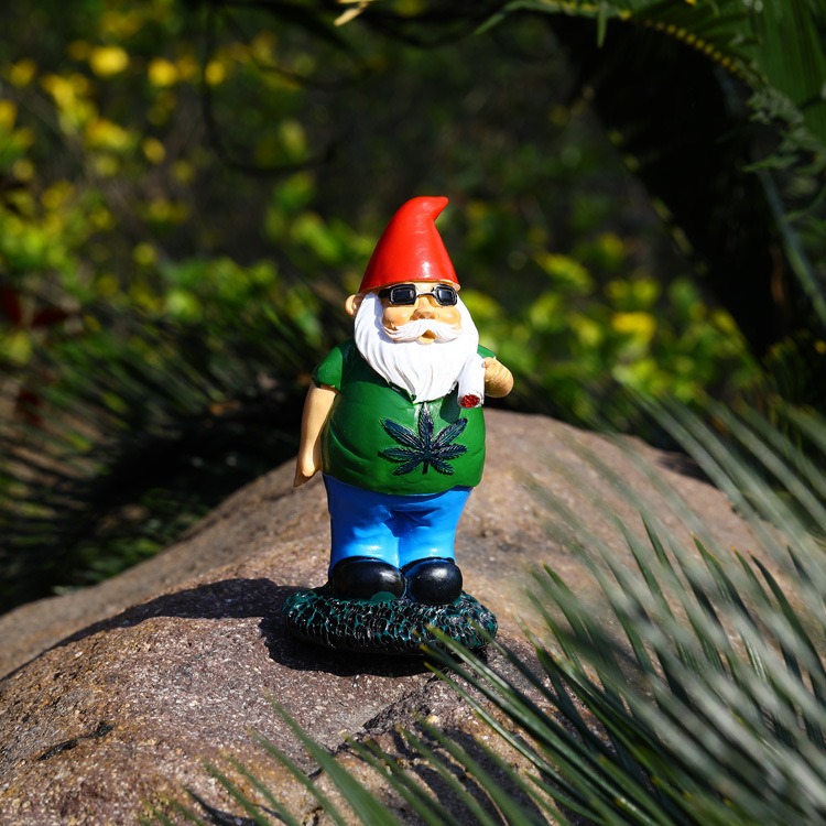 Gnome figurine on a rock among foliage in a natural outdoor setting