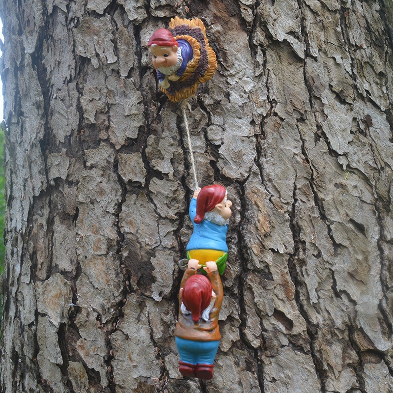 Gnome climbing set mounted on a tree trunk outdoors