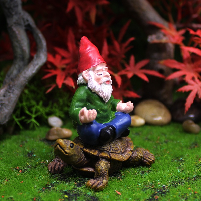 Front three-quarter view of a gnome on a turtle among moss and stones