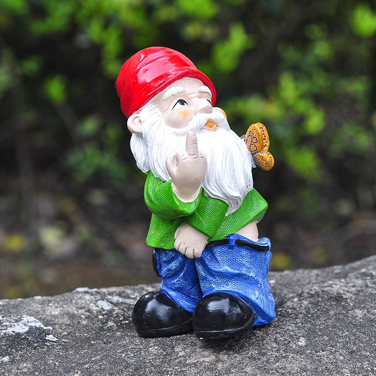 Resin gnome figurine placed among plants in a garden setting