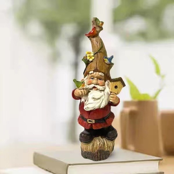 Gnome figurine with birdhouse hat set among garden plants