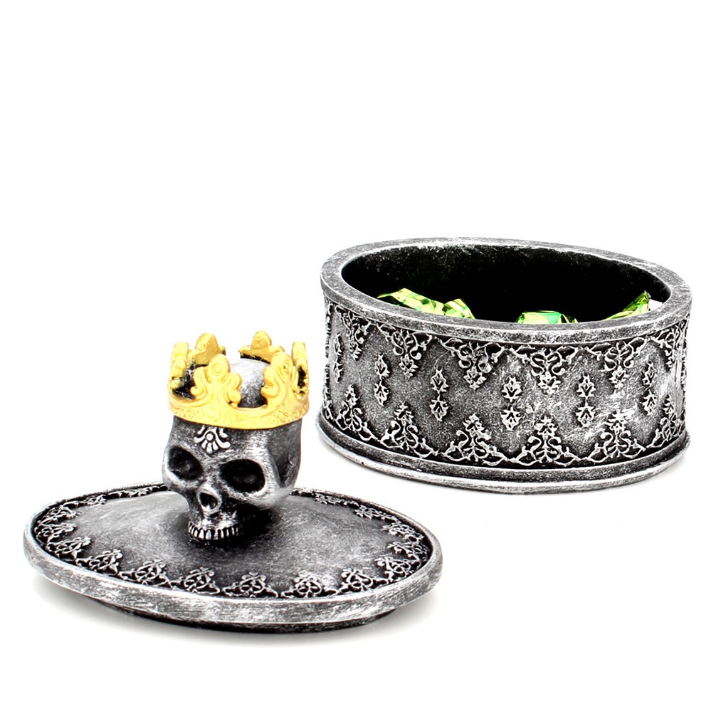 Open silver skull box with lid removed, showing the hollow interior and green crystals
