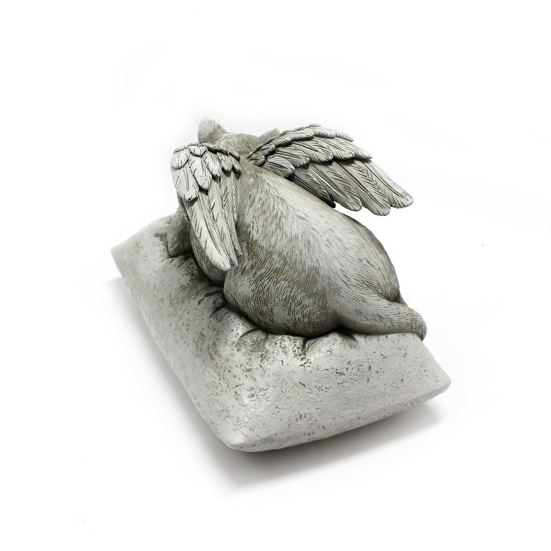 Rear view of angel cat statue showing wings and body contour on pillow