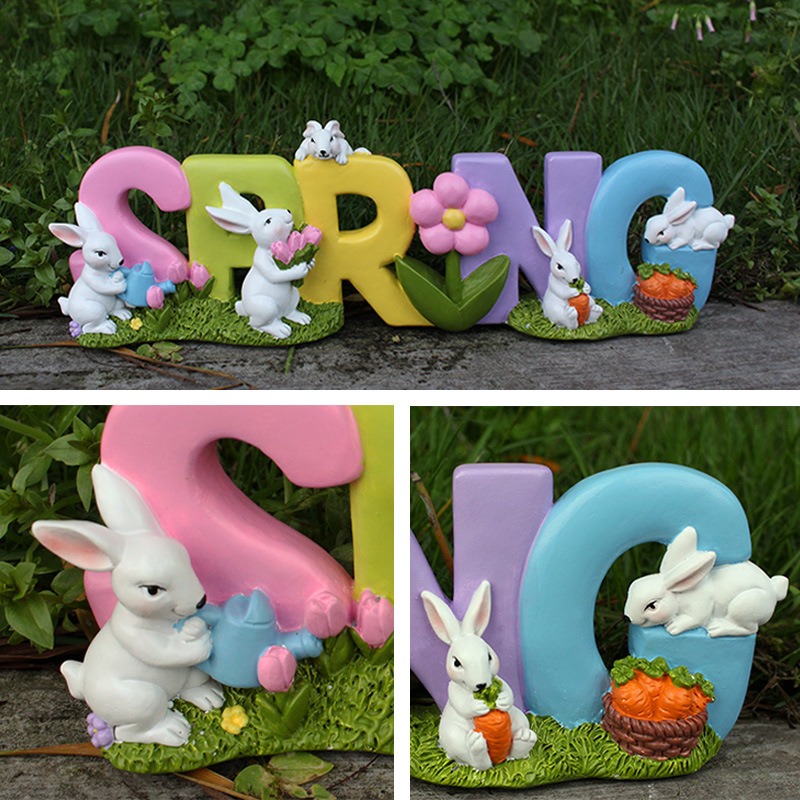 Close-up of rabbit figurines and carrot basket on a grass-textured base