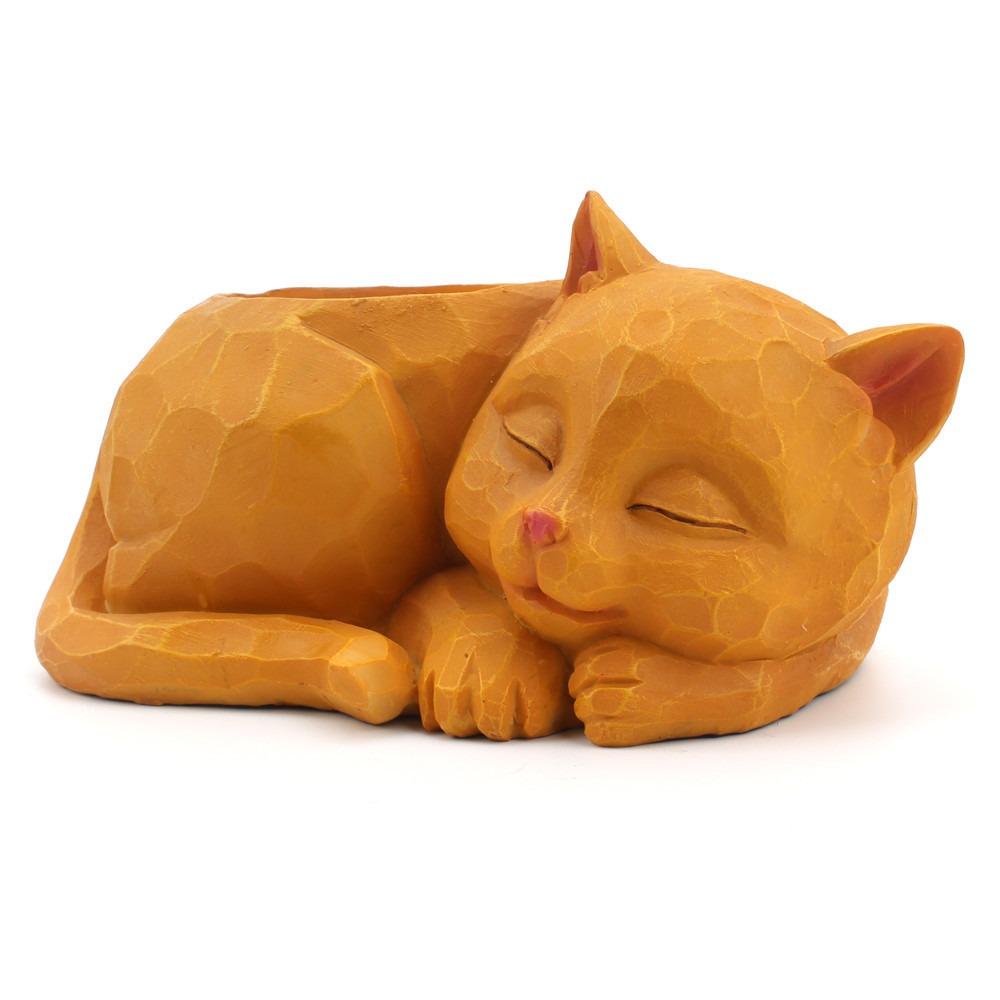 Sleeping cat planter set among ordinary desk and shelf clutter