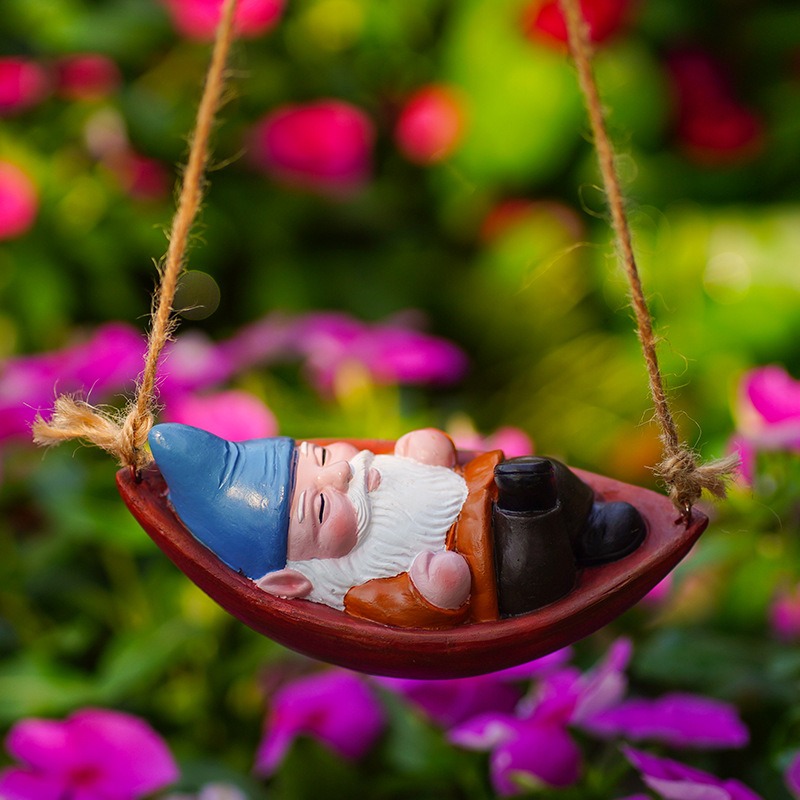 Close view of the painted gnome face and boat with pink flowers behind