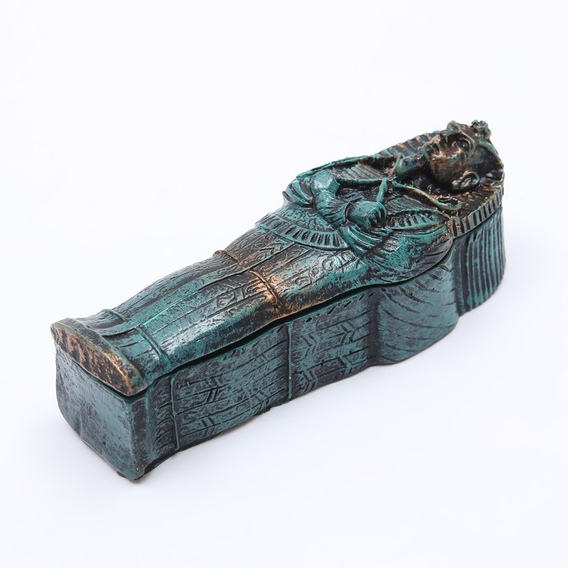 Angled view of closed coffin with lid detail and hieroglyph-style carving