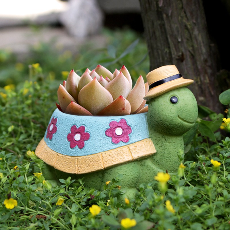 Turtle planter on an outdoor courtyard beside green garden plants
