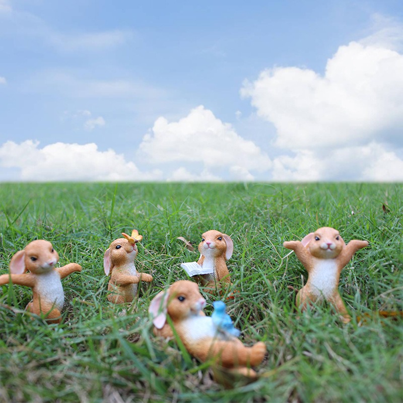 Rabbit figurines set in grass with several poses visible