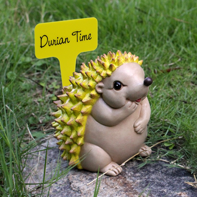 Front view of hedgehog figurine with Durian Time stake on lawn
