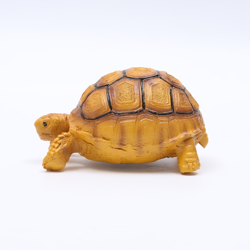 Side profile of resin tortoise figurine showing painted shell texture