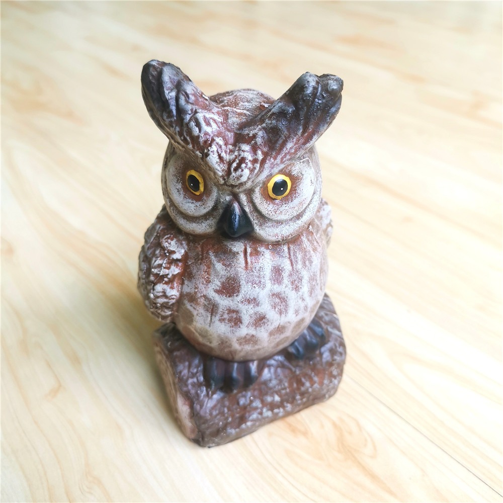 Owl statue placed in a garden setting with stump base