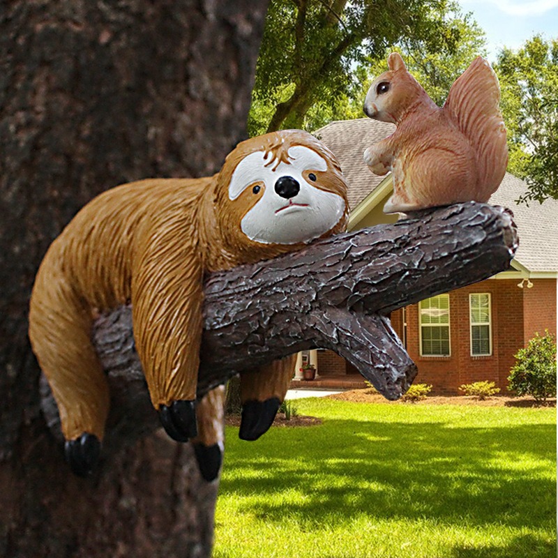 Sloth and squirrel decor on a sunny garden tree trunk by a brick house