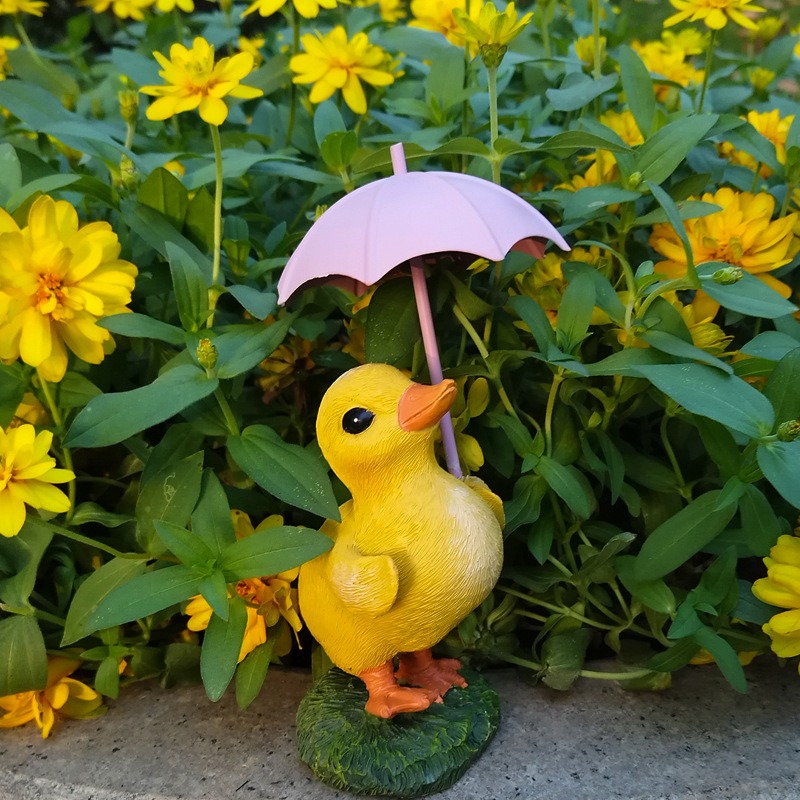 Figurine placed in a green garden corner with leaves in the frame