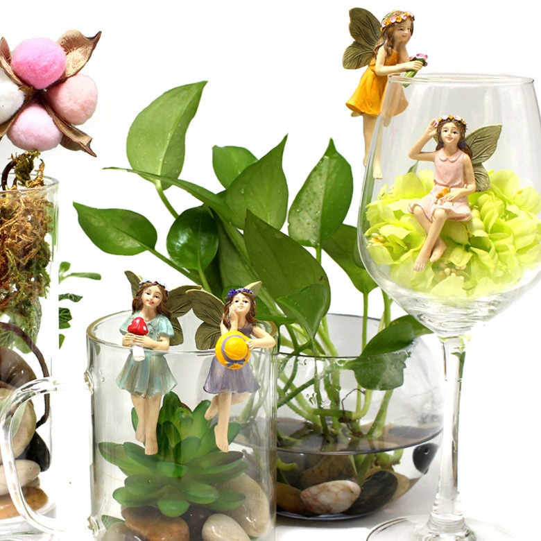 Glass vases with succulents, pebbles and a yellow flower arrangement