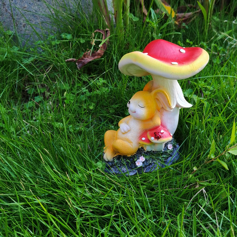 Figurine set in a lawn with a small mushroom and pink flowers
