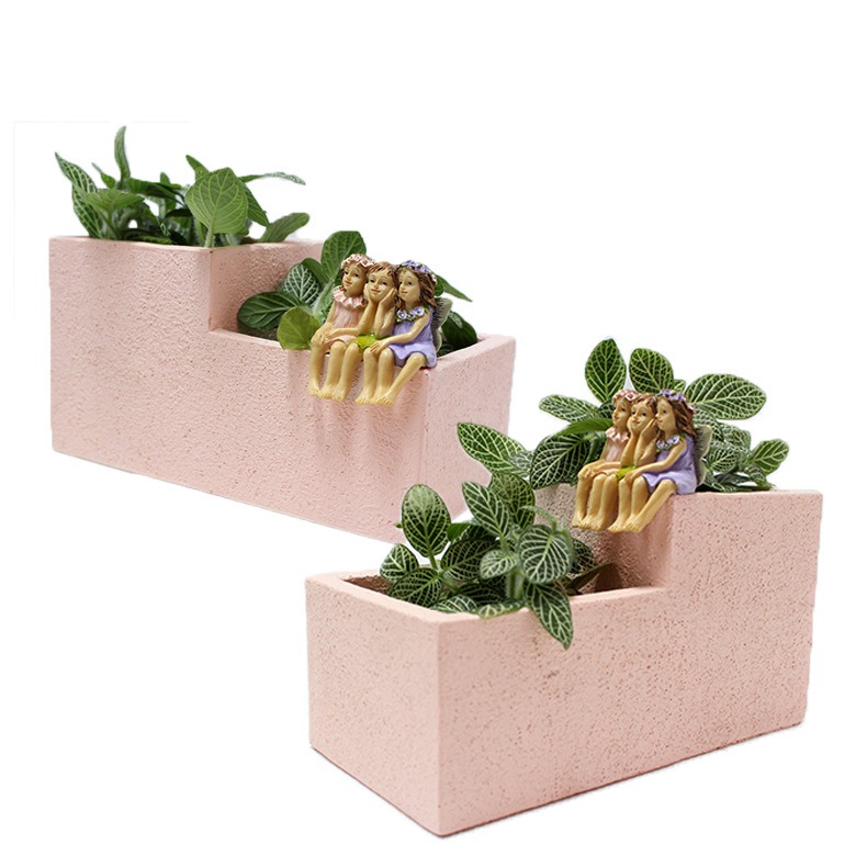 Two pink stepped planters with trailing and striped-leaf plants side by side