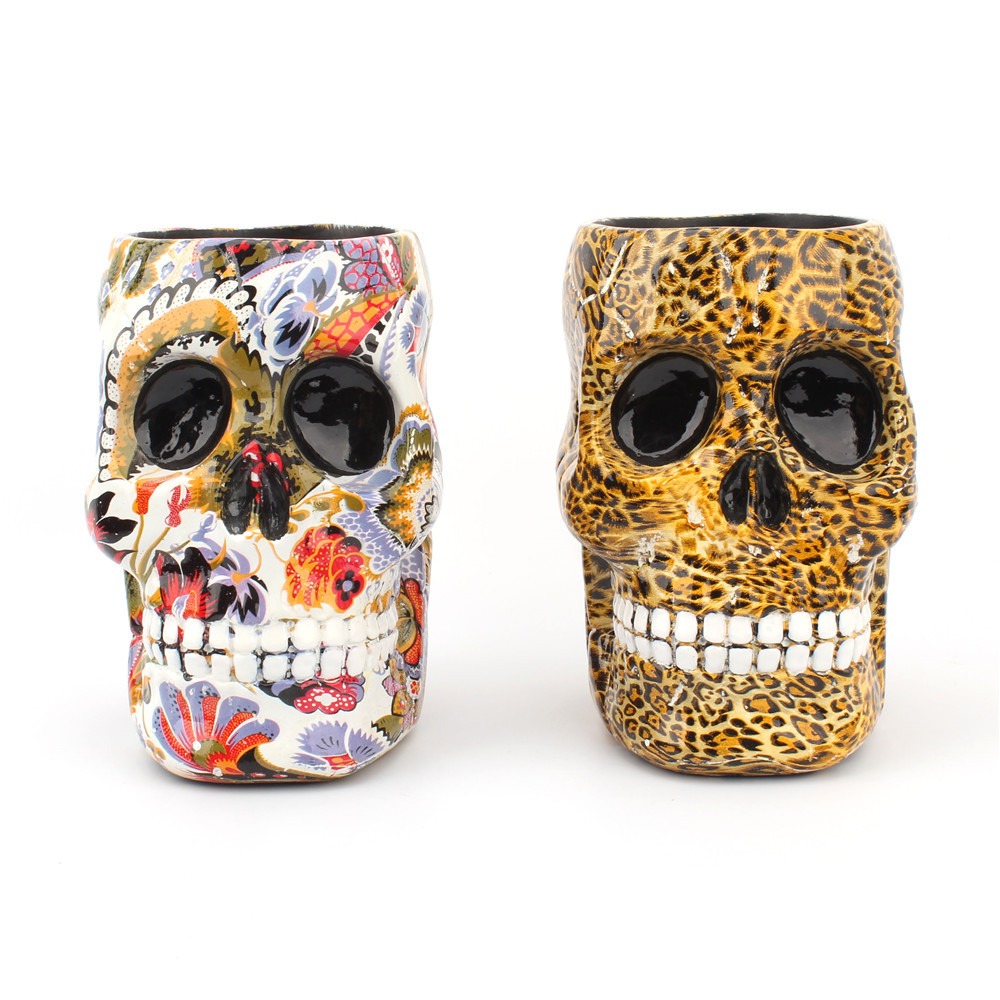 Two skull pen holders in floral and leopard colourways side by side