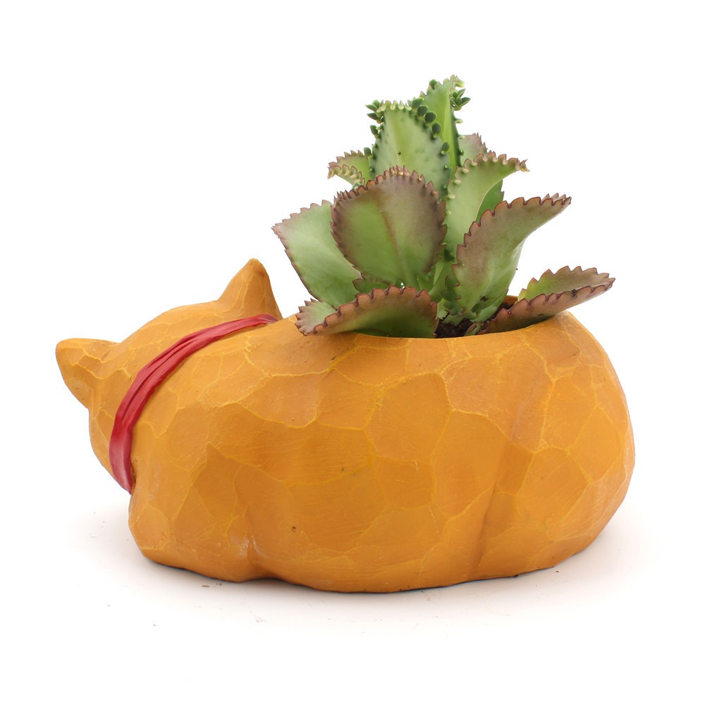 Sleeping cat planter with a small succulent in its open cavity