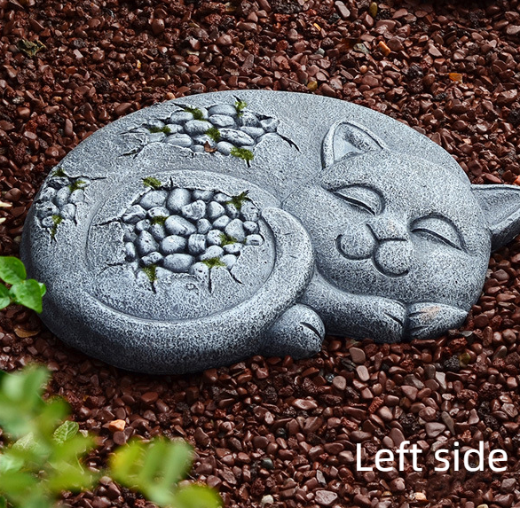 Left-side view of cat stone with pebble detail resting in mulch