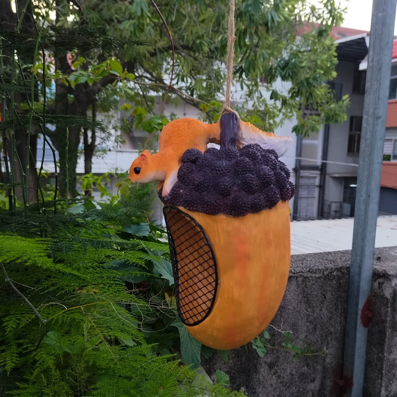 Hand holding the acorn bird house to show its size