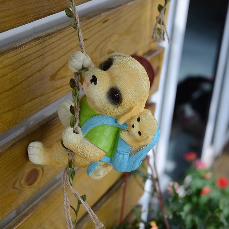 Yellow puppy figurine hugging a baby puppy, clinging to a rope