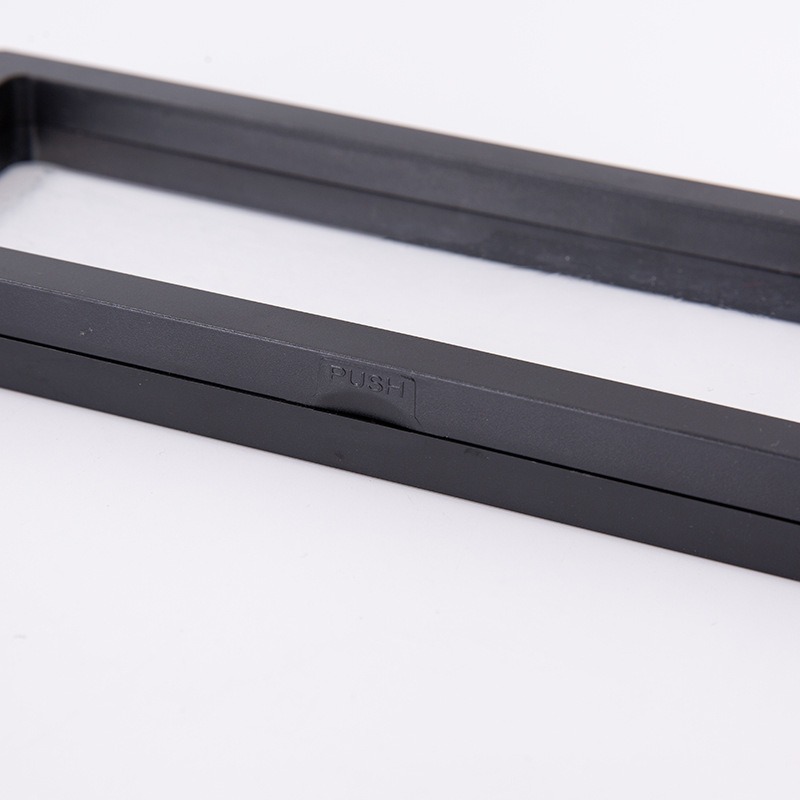 Close-up of black box frame edge with embossed PUSH label